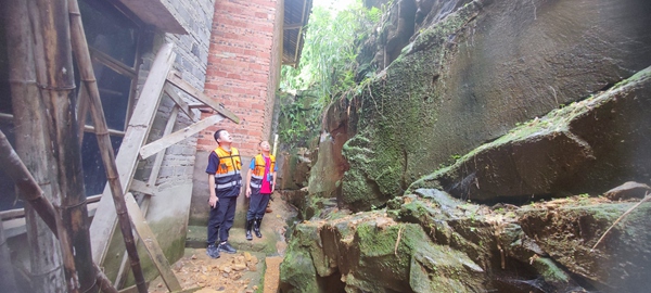 《雨天巡查不松懈》。7月21日，川东南勘察公司驻守地质队员在雨中对垫江县砚台镇漏湾危岩地灾隐患点进行巡查。林松摄