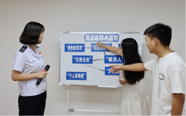 重慶市稅務局第七稽查局稅務人員帶領長江師范學院大學生玩稅收普法連線小游戲。何冰翊攝