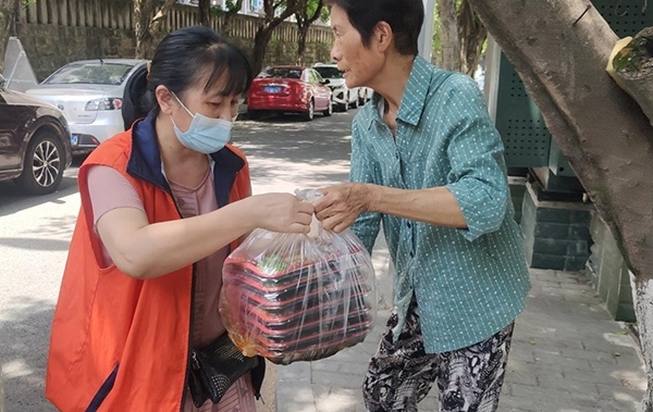 为老人提供上门送餐服务。莲花街道供图