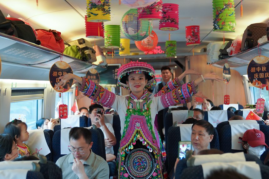 重慶西開往貴陽北的G4859次高鐵列車上，貴州省桐梓縣文化演出人員在車內為旅客表演非遺舞蹈。李文航攝