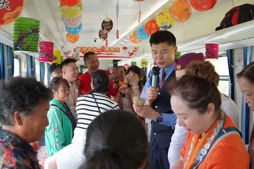遵義開往重慶西的5630次列車上，旅客在集市車廂購買農產品。李文航攝
