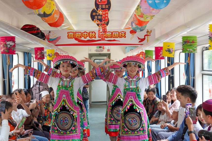 遵義開往重慶西的5630次列車上，桐梓縣文旅局演出人員為旅客表演非遺舞蹈。李文航攝