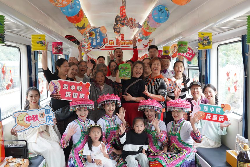 遵義開往重慶西的5630次列車上，旅客、演出人員、列車工作人員合影留念。李文航攝