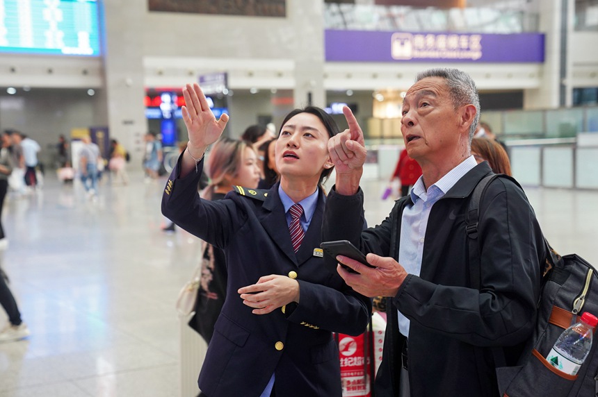 重慶北站，工作人員為旅客作引導。汪亮攝