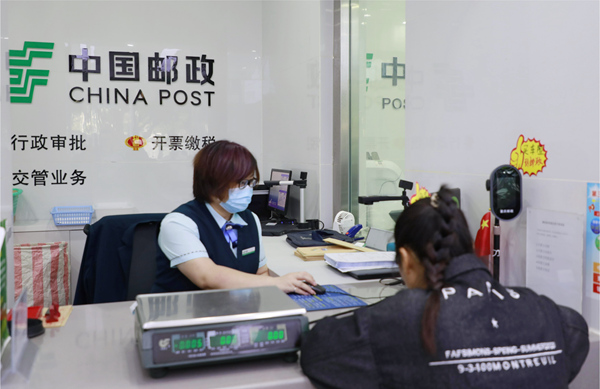 忠县大桥邮政所发票代开点的工作人员正在为市民办理发票代开业务。程熙摄
