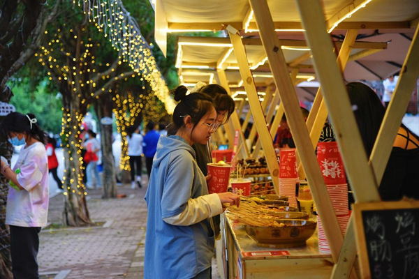 市民逛集市品美食。成蓉摄