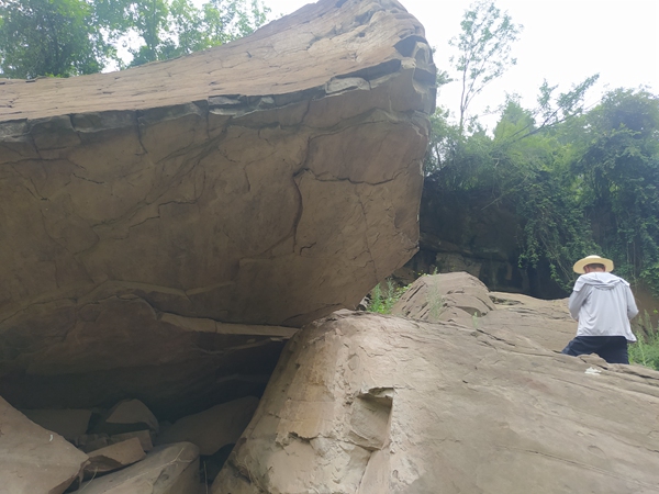 《渺小，但不胆小》。9月3日，在云阳县普安乡姚平村，107地质队驻守地质工程师姜双桃在长江支流磨刀溪两岸的陡壁上详实记录危岩情况。李明亮摄