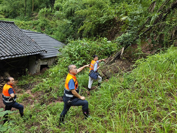 7月27日，市级专家卢丙清（中）、大足区地环站站长潘先卫（左）、南江地质队唐锐（右），在“7.26”暴雨后赶赴大足区中敖镇现场踏勘屋后垮塌情况。庹