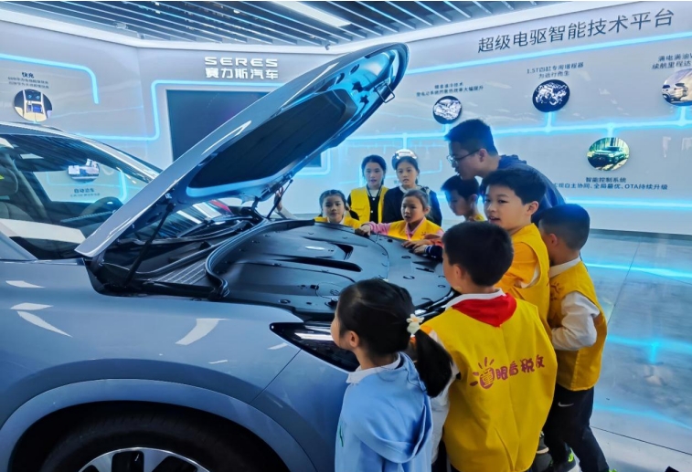 在沙坪坝区青凤科创城赛力斯凤凰智慧工厂，小朋友们正在近距离体验新能源小汽车。何献摄