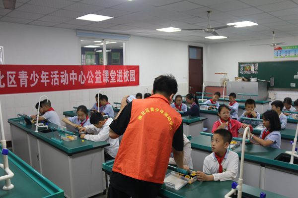 在渝北回兴小学，渝北区青少年活动中心的老师正在给青少年科普机器人知识。渝北区青少年活动中心供图