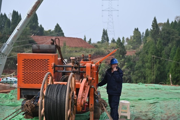 川渝特高壓線路工程（重慶段）現場張牽手正在用對講機實時溝通施工情況。唐甜甜攝