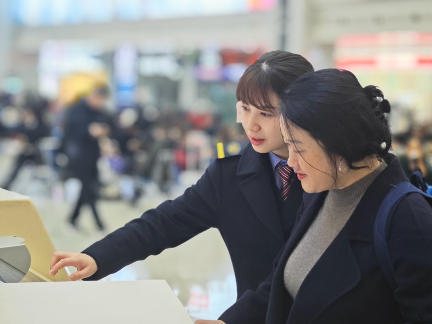 重庆北站工作人员帮助旅客查询车票信息。魏伟摄