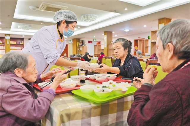 光大百龄帮·龙山老年养护中心，护理人员帮助老人用午餐。（本报资料图片）记者 梅耀 摄\视觉重庆