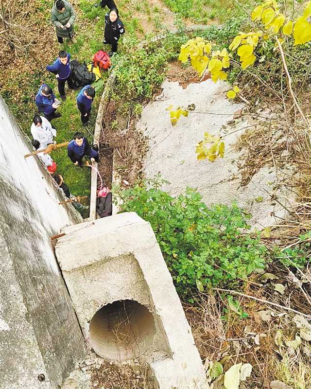 1月11日，巴南区华熙文体中心对面一排水管附近，消防、医护人员正在救援被困的男孩。（巴南区公安分局供图）