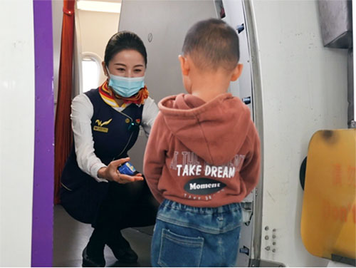 西部航空“紫辰”示范组乘务员迎接儿童旅客。西部航空供图