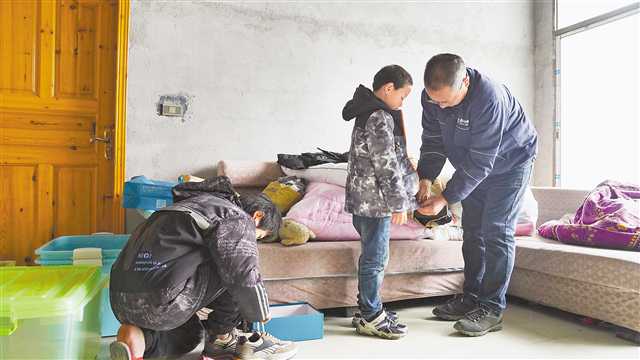 瞿秀泉(右一)为受助者陶孙波(左一)、陶孙翔(左二)兄弟送去暖冬物资。(资料图片)(受访者供图)