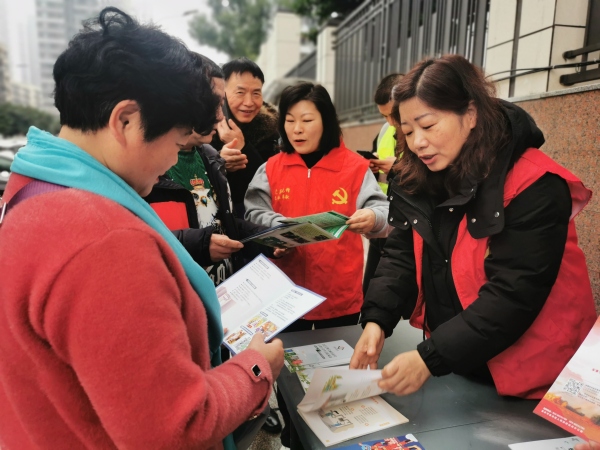 工作人员向居民发放宣传资料、解释惠民政策。汪年福 摄