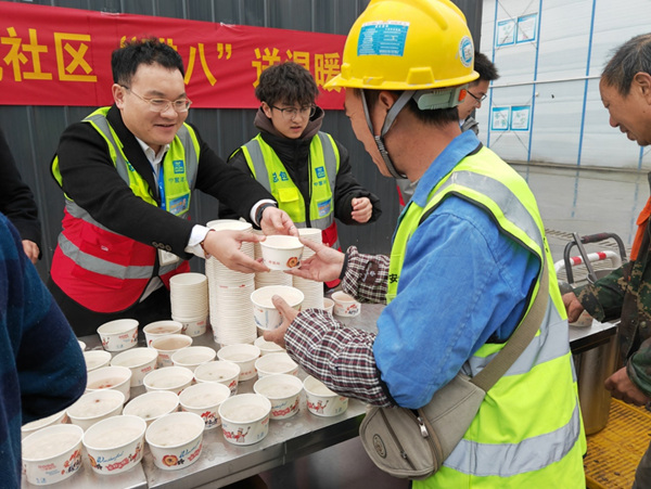 果园港国际枢纽经济产业园二期项目，工人收到热气腾腾的腊八粥。中建八局供图