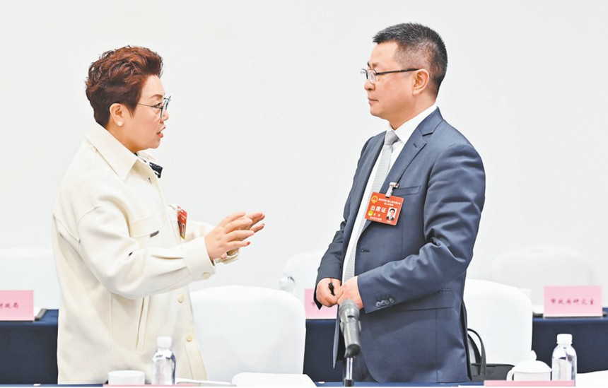 　1月22日，市人大代表在会议间隙就引进AI机器人智能驾培系统的建议展开讨论。记者 齐岚森 摄/视觉重庆