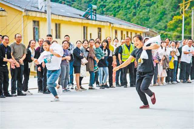 城口县修齐镇枇杷村举办乡村趣味运动会，背谷子接力赛、刮洋芋、锯木头等活动，引得现场掌声、笑声不断。（受访者供图）