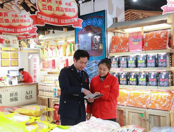 春节临近，沙坪坝区税务人员在陈麻花门店宣传税收优惠政策。何献摄