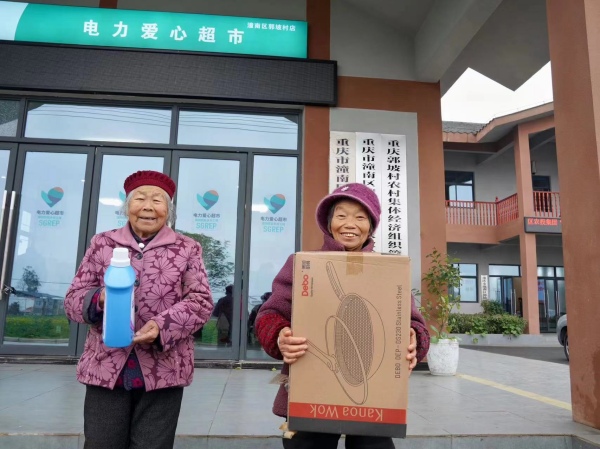 村民展示用积分在“电力爱心超市”兑换到的年货。国网潼南供电公司供图