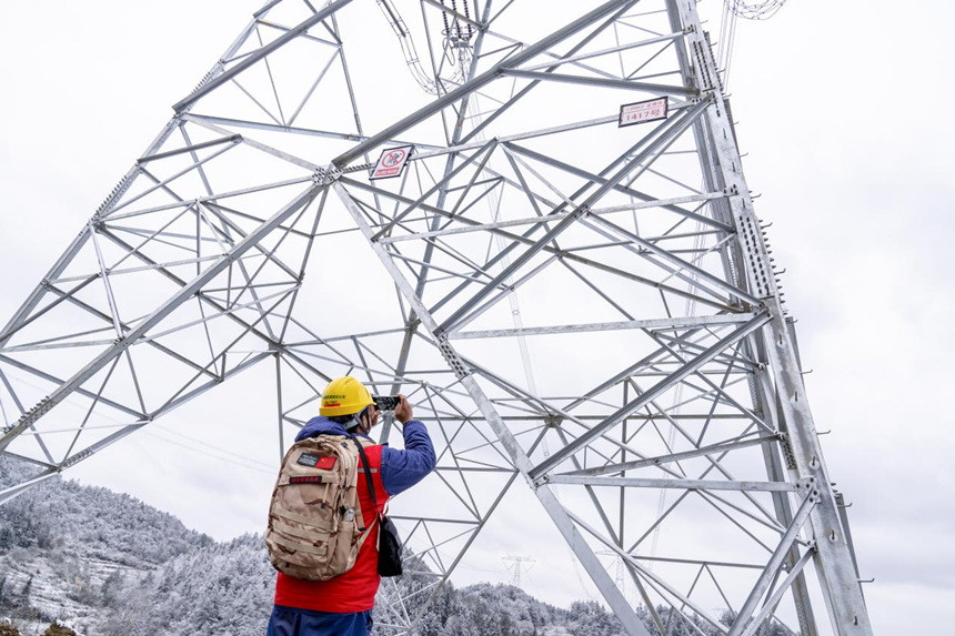 2月9日，在彭水县中岭山，国网重庆电力员工对电力线路开展冰雪特巡。牟伟摄
