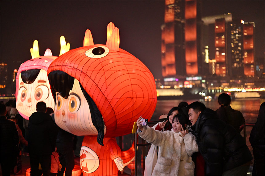 2月9日除夕夜，南岸区南滨路，灯光秀与重庆夜景交相辉映，吸引众多市民前来观看。郭旭摄