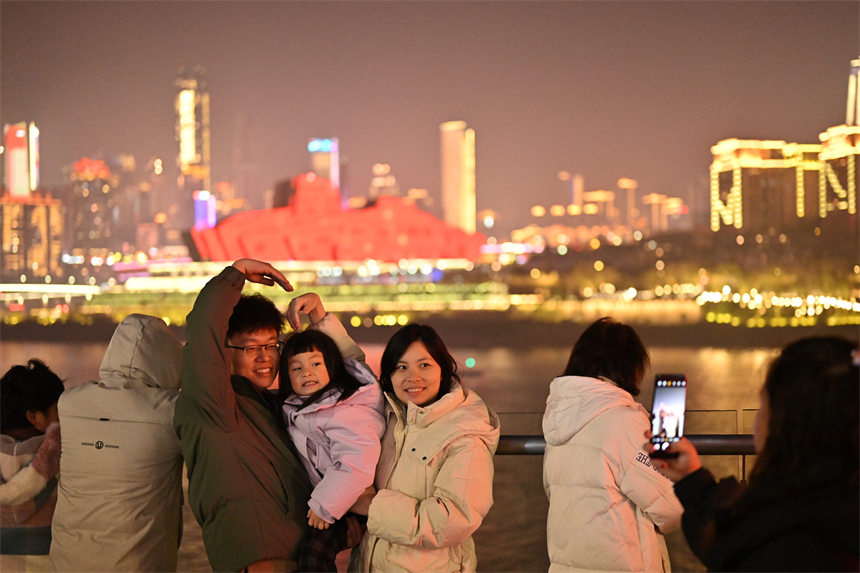 2月9日除夕夜，南岸区南滨路，灯光秀与重庆夜景交相辉映，吸引众多市民前来观看。郭旭摄