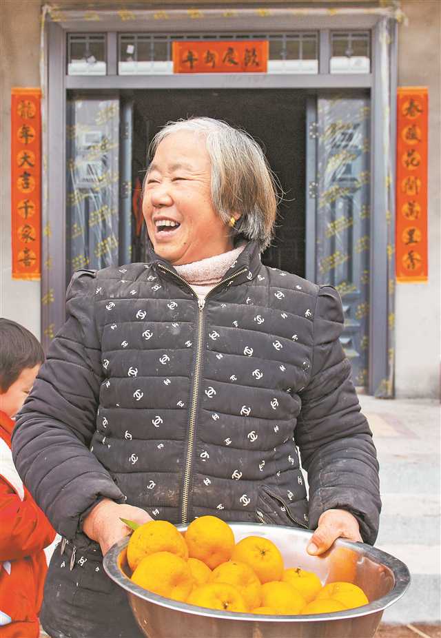 1月25日，万州区长滩镇太白溪村，黄远生的老婆在新房前满脸笑容。