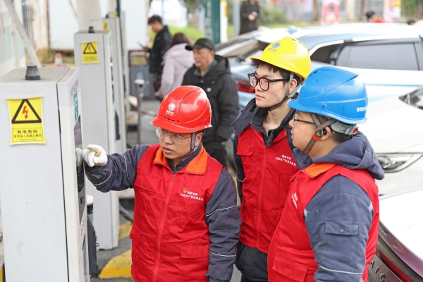国网重庆彭水供电公司高谷供电所工作人员文雪松（左一）和同事正在对包茂高速彭水服务区充电站进行巡检。蔡光进摄