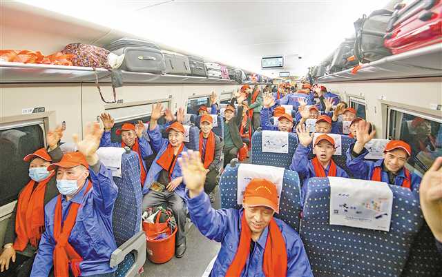 二月十九日，重庆西站，登上专列的务工人员正向家乡的人们挥手再见。记者 郑宇 摄\视觉重庆