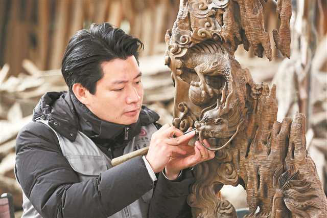 2月6日，巴南区石龙镇大兴村，巴南区非遗周氏木作代表性传承人周奎专心创作，他的木雕产品很受年轻人欢迎。通讯员 李攀 摄/视觉重庆