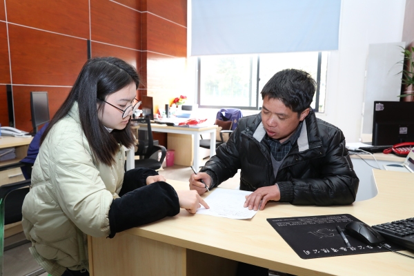 何明建填写入职申请表。张丹摄