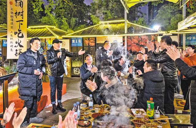 2月22日，“黄桷坪老火锅”店内，阿多（左二）与客人互动唱歌。记者 何赛格 摄/视觉重庆