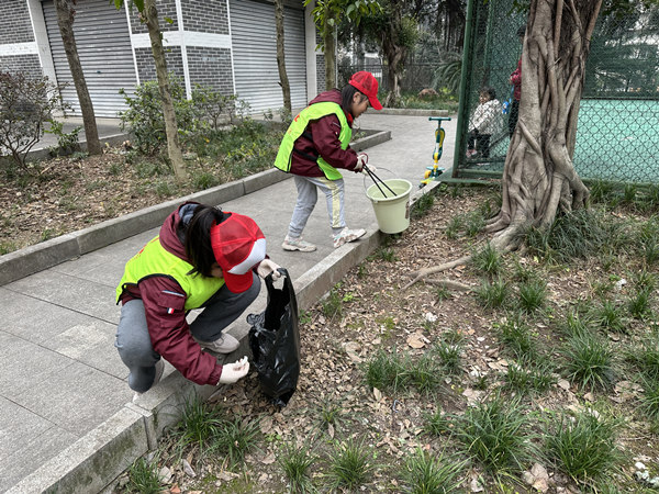 同学们在捡拾绿化带内的垃圾。康兴路社区供图