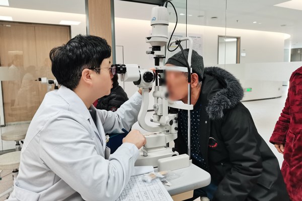 张晓城为患者检查眼部情况。重庆南坪爱尔眼科医院供图