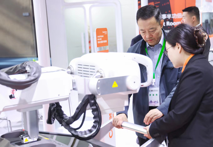 在重慶舉行的2024中國醫學裝備展覽會上，現場工作人員演示如何操作手術機器人給向日葵“做手術”。