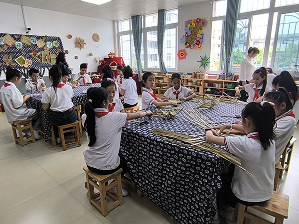 赶水小学乡村少年宫的手工活动室内，同学们正在用竹条编织手工作品。綦江区融媒体中心供图