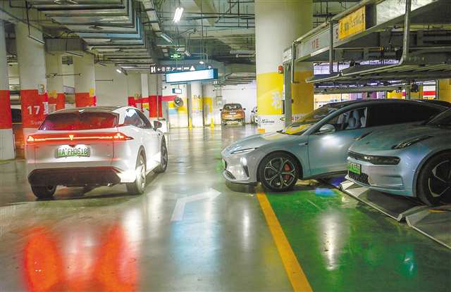 4月11日，渝中区国泰广场地下停车场，一辆新能源车（右二）正尝试停入机械停车位。