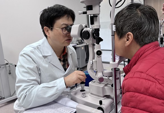 张晓城为患者检查术后眼睛状况。重庆南坪爱尔眼科医院供图