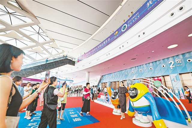 四月十七日，觀眾在第四屆消博會展館中與吉祥物合影。新華社記者 郭程 攝