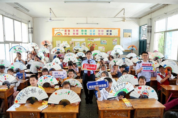 在開州區臨江鎮中心小學，同學們展示自己親手做的稅法主題手工折扇。趙詩琦攝