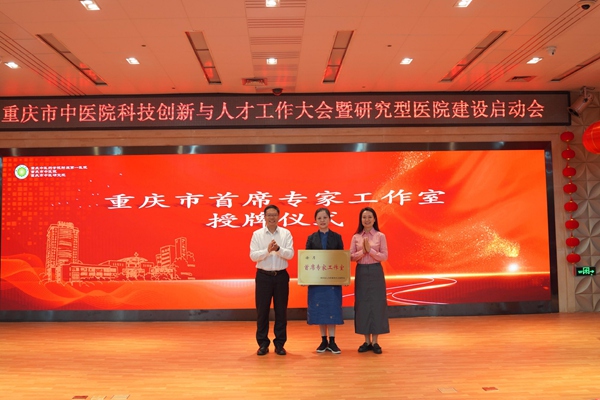 重庆市人力社保局副局长谢辛（左一）为“重庆市首席专家工作室”授牌。老师一边讲课一边c我供图