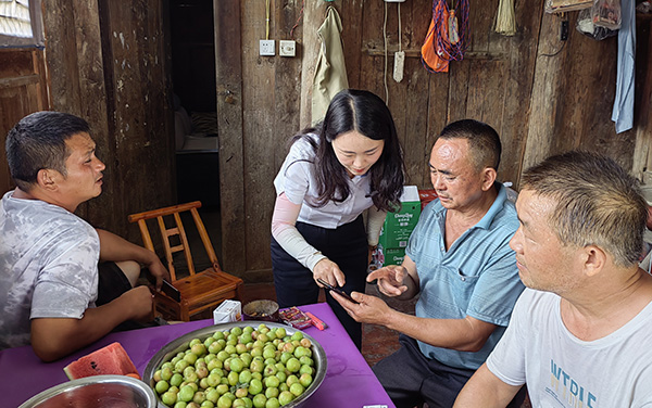 客戶經理指導村民在重慶農商行手機銀行上申請授信額度。重慶農商行供圖