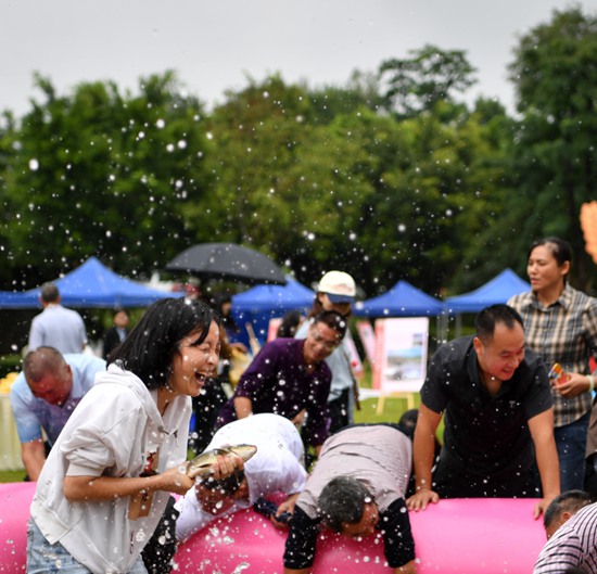在西彭镇举行的九龙坡区庆祝2023年中国农民丰收节主会场活动中，市民进行摸鱼比赛。 周邦静摄