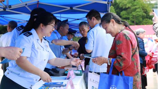 在璧山區民法典宣傳月集中宣傳活動現場，稅務、公安等部門工作人員向來往市民發放宣傳資料、宣傳講解各類法規。黃小琦攝