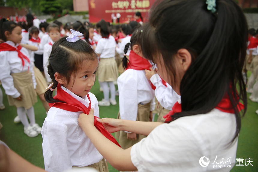 高年級學生為新入隊的少先隊員佩戴紅領巾。人民網記者 劉政寧攝