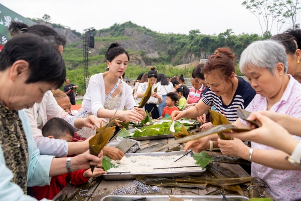 游人和村民在包粽子迎端午。秦廷富 摄