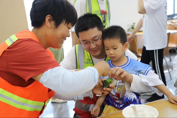 項目人員正在體驗包粽子。中建八局供圖